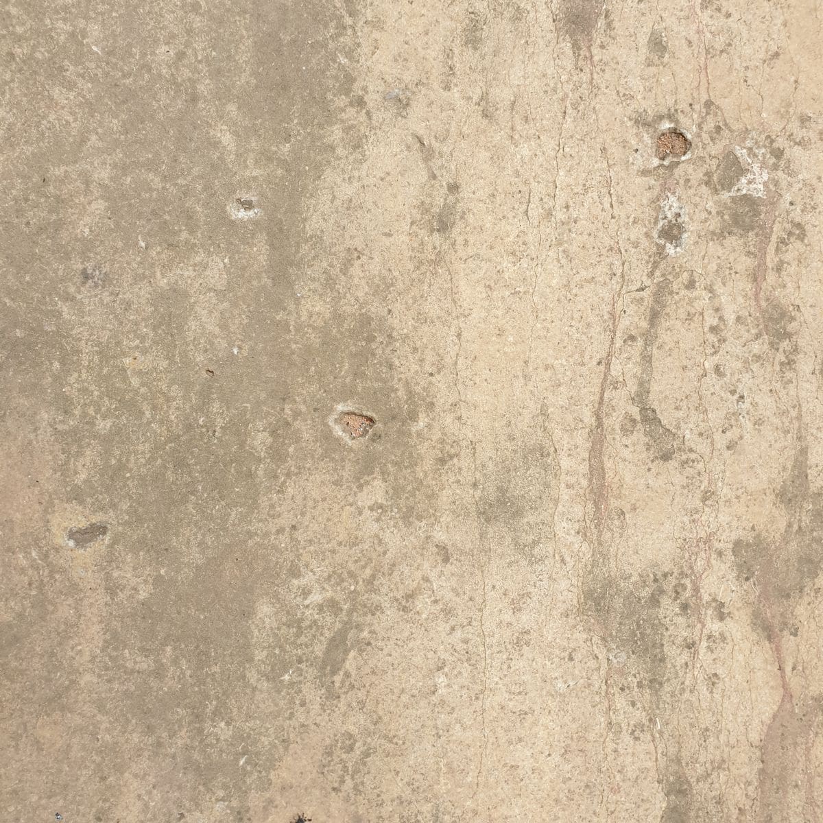 Surface texturée recouverte d'une fine poussière de chantier illustrant les niveaux de salissure