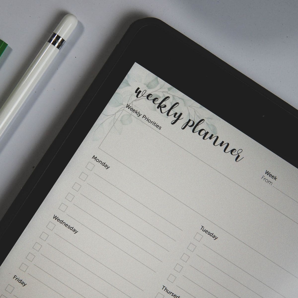 Personne prenant des notes sur un agenda à côté d'un téléphone, préparant les questions à poser à un prestataire de nettoyage