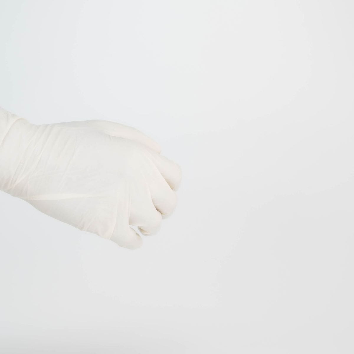 Gant de ménage en plastique blanc sur fond neutre, symbole du nettoyage de fin de bail